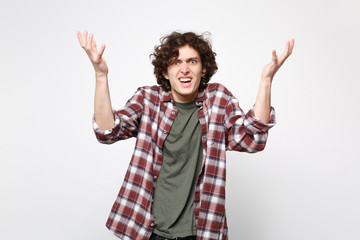 Portrait of irritated perplexed young man in casual clothes swearing and spreading hands isolated on white wall background in studio. People sincere emotions, lifestyle concept. Mock up copy space.