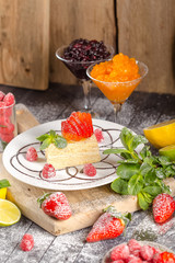 napoleon sweet cake on a plate, lay on an old wooden sliced vintage rustic board, jam, powdered...