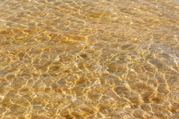 Fototapeta na wymiar Clear sea water golden sand with reflection sun