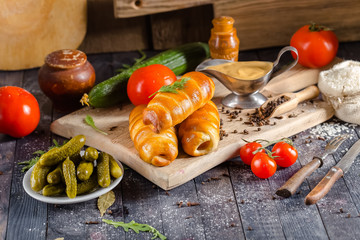pies, loaf bread, dough on a wooden vintage cutting board old rustic, mustard sauce-dish, tomato,...