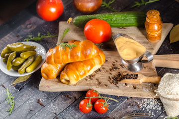 pies, loaf bread, dough on a wooden vintage cutting board old rustic, mustard sauce-dish, tomato,...