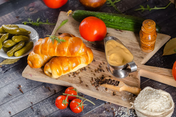 pies, loaf bread, dough on a wooden vintage cutting board old rustic, mustard sauce-dish, tomato,...