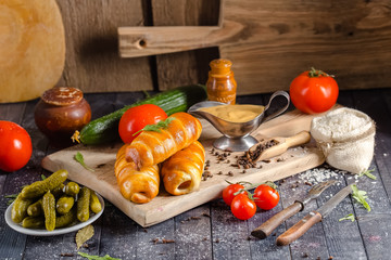 pies, loaf bread, dough on a wooden vintage cutting board old rustic, mustard sauce-dish, tomato,...