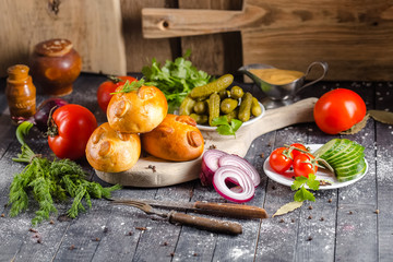 pies, loaf bread, dough on a wooden vintage cutting board old rustic, mustard sauce-dish, tomato,...