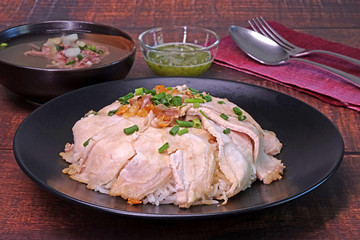 Slice grilled pork with rice, topping with fried pork rinds, pickled garlic and spring onions served with pork spare ribs soup and green spicy chili sauce. Famous Chinese / Cantonese cuisine.