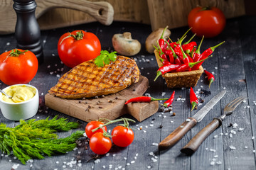 grilled kebab grilled meat steak lies on a wooden vintage old board rustic, chili, with tomatoes,...