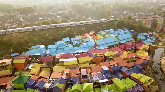 Drone shot of a wonderful Colorfull village in Java, Indonesia with a train passing