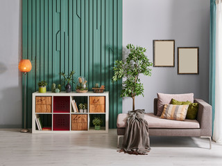 Green decorative wall and grey background style, white bookshelf box style and grey sofa decoration frame and vase of plant.