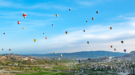 Colorful hot air balloons flying over rock landscape at Cappadocia Turkey
