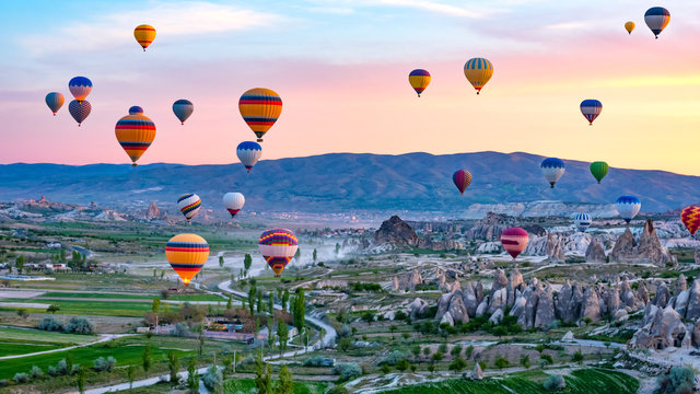 Colorful hot air balloons flying over rock landscape at Cappadocia Turkey