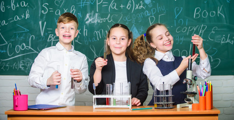 Group school pupils study chemical liquids. Girls and boy student conduct school experiment with liquids. Check result. School chemistry lesson. Test tubes with colorful substances. School laboratory