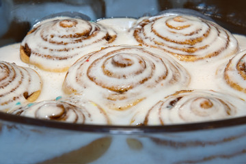 Baked cinnamon buns were poured over with a white icing to soak