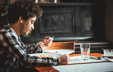 Young african american man eating lunch at restaurant