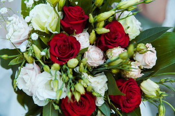 bridal bouquet in the hands against the background of the dress
