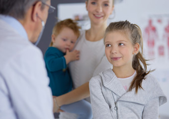 Girl and doctor with stethoscope listening to heartbeat