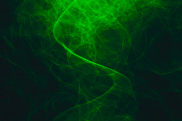 Fototapeta premium Green neon intertwined smoke. Abstract black background. Neon lights texture.