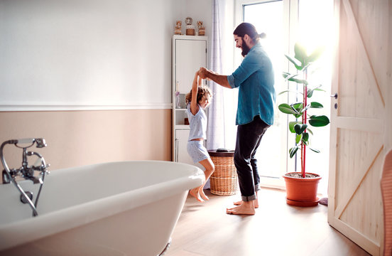 Small Girl With Young Father In Bathroom At Home, Having Fun.