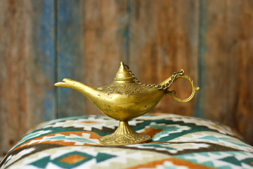 Lamp of wishes in a hand. Vintage Aladdin lamp background.
