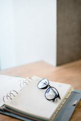 open notebook and black glasses laying on the table