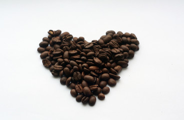 Coffee beans in heart form on white.