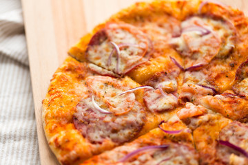 food, culinary and eating concept - close up of sliced homemade pizza on wooden table