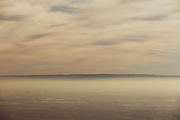 Landschaft Rheinebene mit Windrädern unter einer Nebeldecke und Wolkendecke