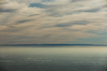 Landschaft Rheinebene mit Windrädern unter einer Nebeldecke und Wolkendecke
