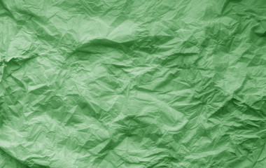 Crumpled sheet of paper in green color.