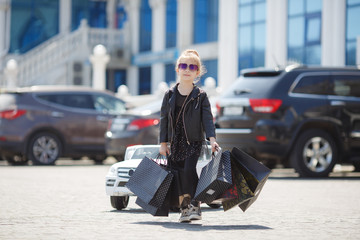 Fashion trend. Fashion shop. Little girl with bunch packages. Seasonal sale. Fashion girl customer. Happy child in shop with bags. Shopping day happiness. Birthday girl shopping. Fashion boutique