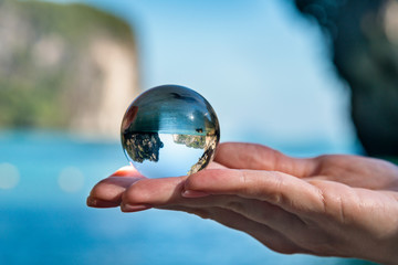 Travel concept, woman holding glass crystal ball