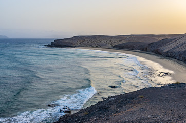 Landscape of a beach with a sailboat crossing the horizon