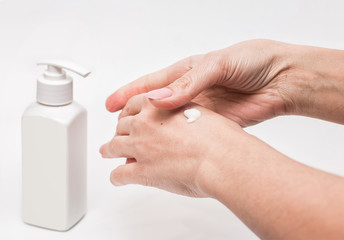Woman hands with cream. Woman applying moisturizer cream on her hands for clean and soft skin. Light background. Health and beauty concept. Front view. 
