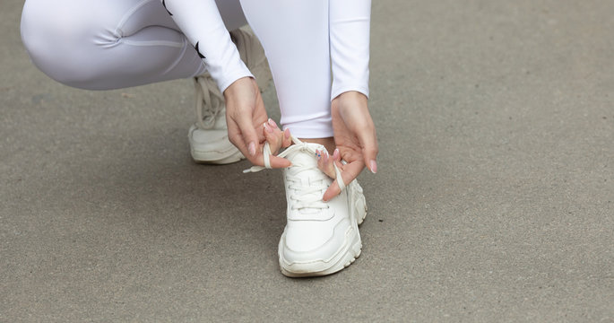 Young woman runner tying shoelaces with copy space, healthy lifestyle and sport concepts. 