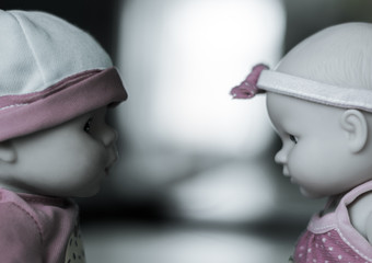 Two dolls sit face to face. The concept of confrontation between the two sides