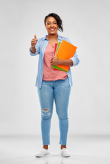 education, school and people concept - happy african american young student woman with notebooks...