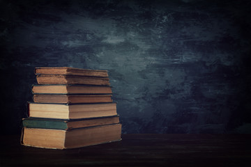 stack of antique books on old wooden table. fantasy medieval period and religious concept