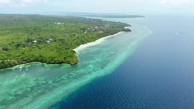 Aerial: Flying over tropical beach turquoise water coral reef , Tomia island Wakatobi National Park Indonesia Maldives Polynesia white sand beach