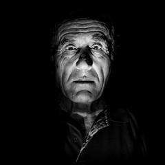 Portrait of old caucasian man. Black and white shot, low-key lighting. Isolated on black.