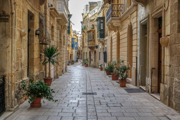 Fototapeta na wymiar View of narrow street in the historical center of Birgu (Vittoriosa), Malta