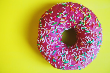 pink donut on a yellow background close