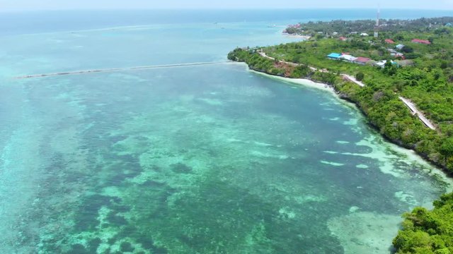 Aerial: Flying over tropical beach turquoise water coral reef , Tomia island Wakatobi National Park Indonesia Maldives Polynesia white sand beach