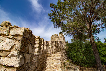Fototapeta na wymiar Blue sky and white clouds in the background and in the foreground part of the walls of a castle