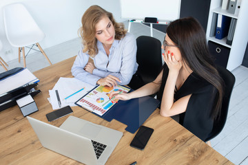 Two business woman investment consultant analyzing company annual financial report balance sheet...