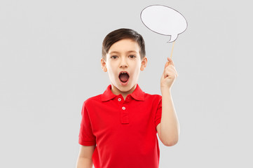party props, photo booth and communication concept - shocked and speechless little boy in red polo t-shirt holding blank speech bubble over grey background