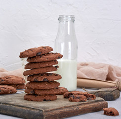 stack of round chocolate chip cookies on a brown wooden board
