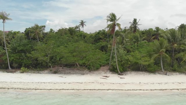 Aerial: Flying over tropical beach turquoise water coral reef , Tomia island Wakatobi National Park Indonesia Maldives Polynesia white sand beach. Native cinelike D-log color profile