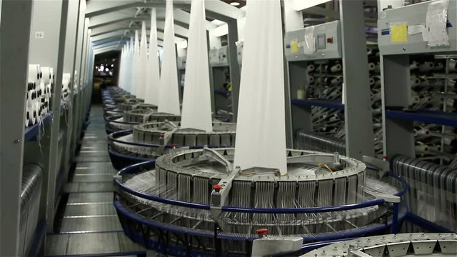 Textile industry - yarn spools on spinning machine in a factory