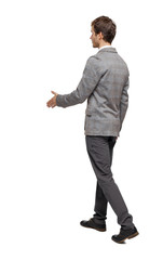 Back view of a walking businessman who stretches his hand for a