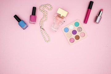 Woman's accessories and make up products on pink background 