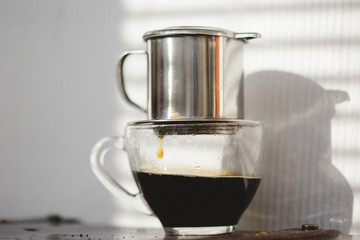 Coffee brewing on sunset. Traditional Vietnamese phin filtered coffee minimalist style.